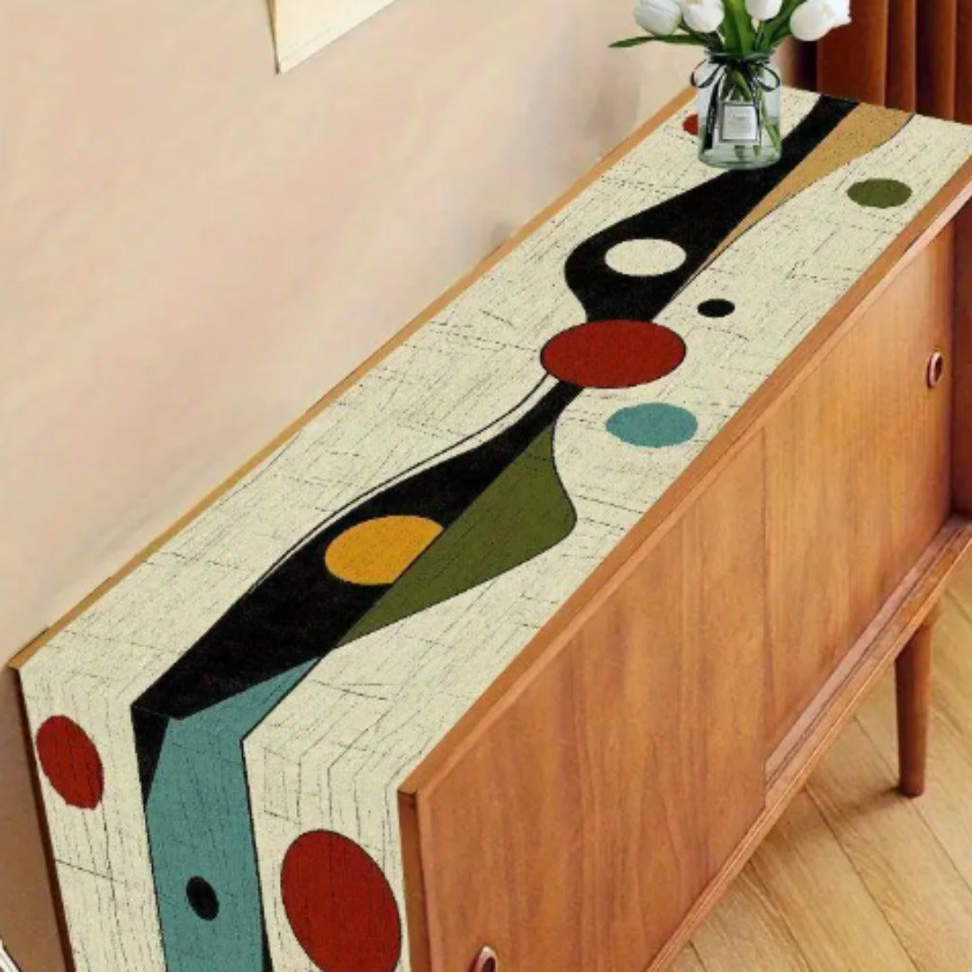 Abstract geometric table runner displayed along a wooden sideboard.