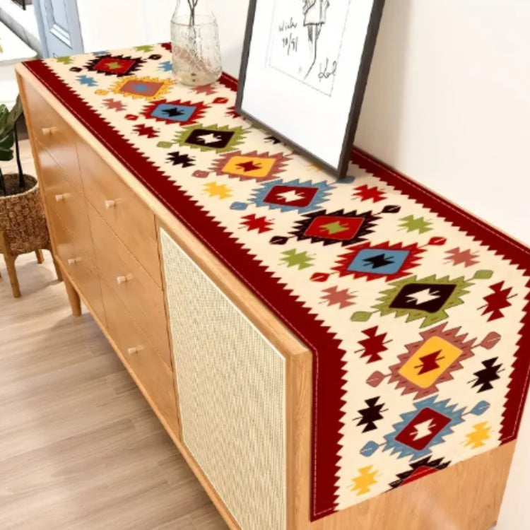 Red-bordered geometric table runner displayed along a wooden sideboard.
