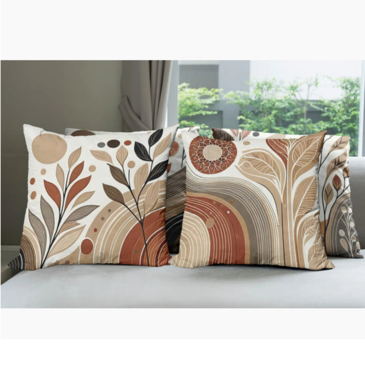 Close view of cream cushion covers with brown leaves and rust abstract shapes.