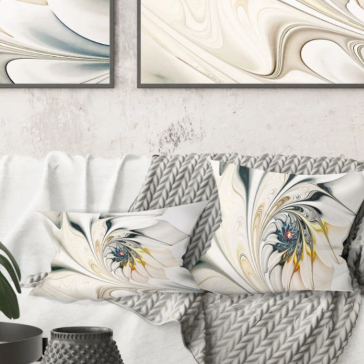 Two pale cushion covers with flowing blue, grey and yellow floral designs on a white sofa.