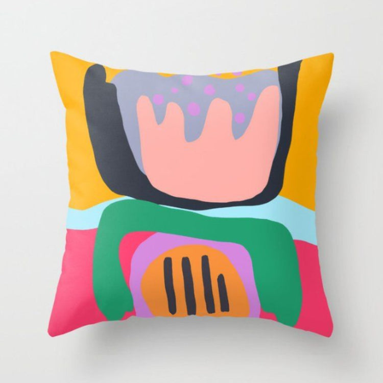 Cushion cover with large pink, green, yellow and blue abstract floral shapes.