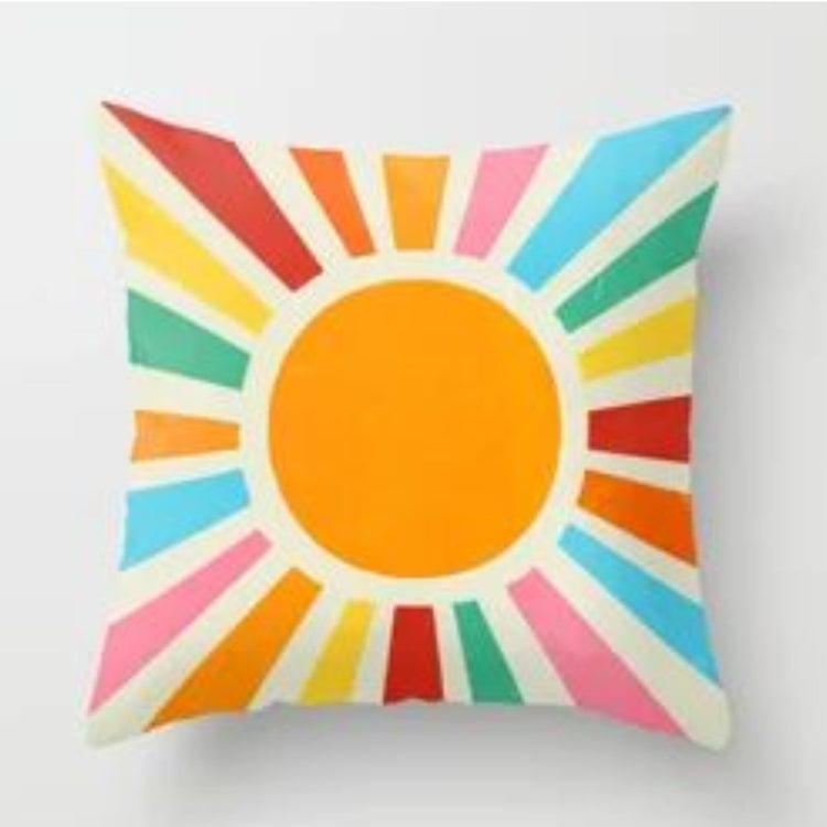 Cream cushion cover with a large orange sun and multicoloured rays.