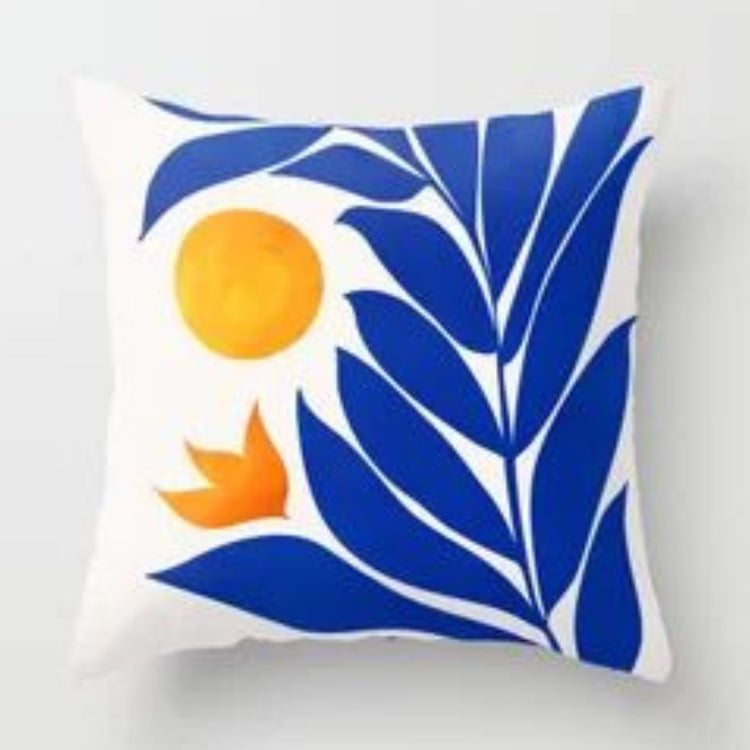 White cushion cover with a large blue leafy stem and an orange sun.