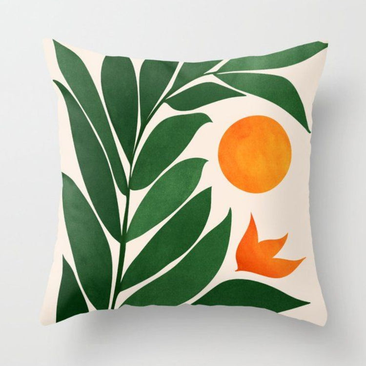 Cream cushion cover with broad green leaves and orange circles.