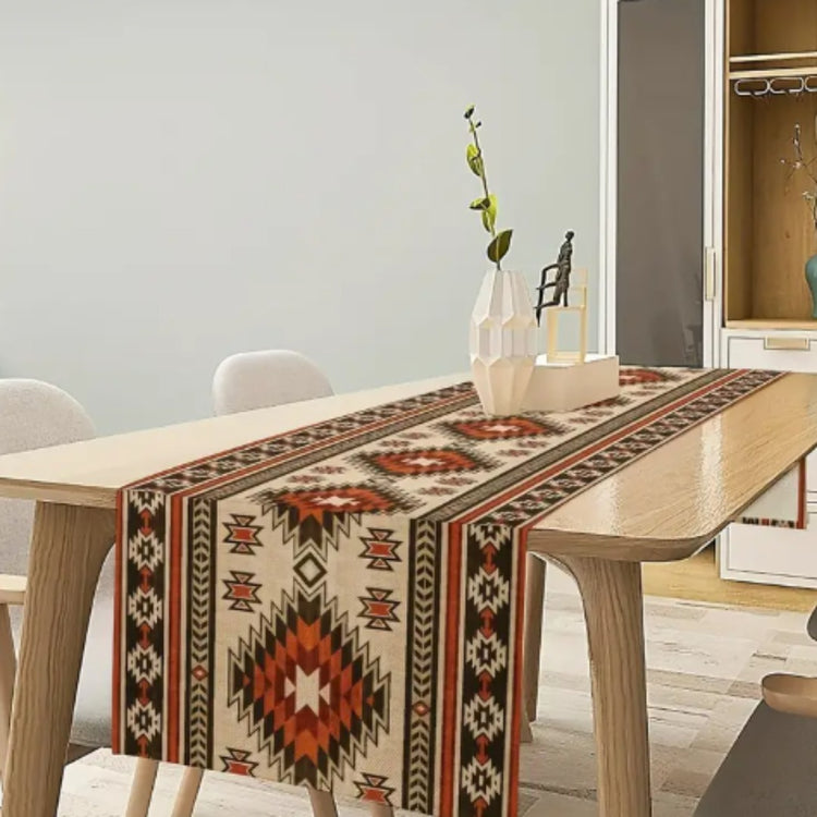 Cream table runner with rust and black geometric diamonds on a wooden table.