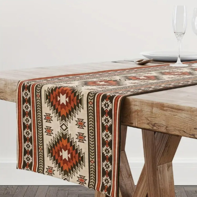 Cream table runner with rust and black geometric diamonds on a wooden table.
