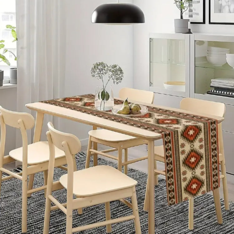 Cream table runner with rust and black geometric diamonds on a wooden table.