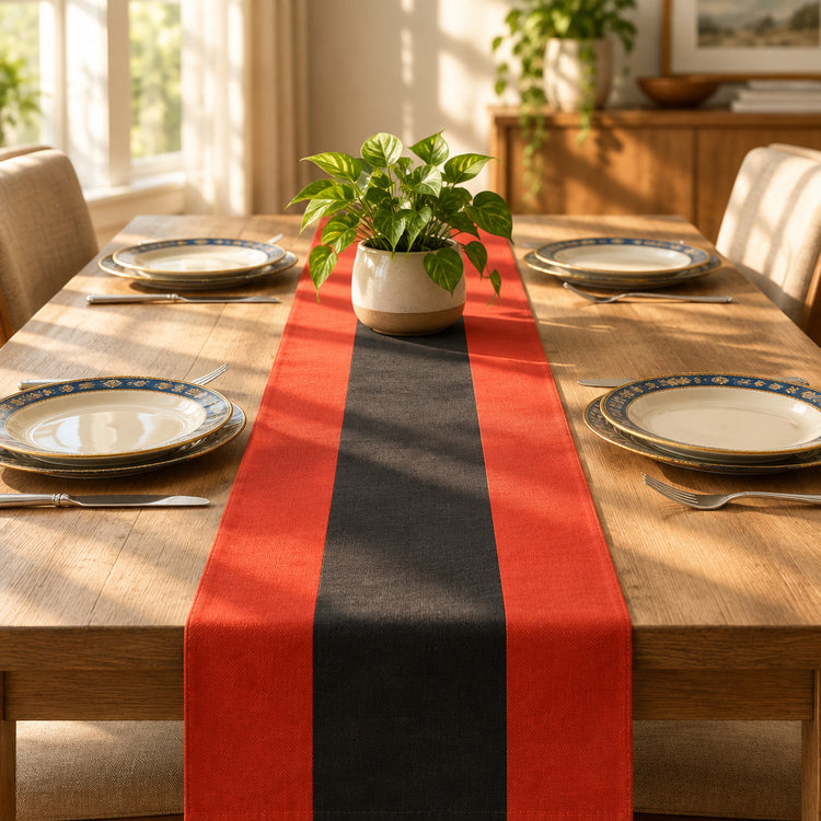 Red and black striped table runner on a wooden dining table set with plates.