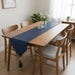 Plain navy table runner on a wooden dining table.