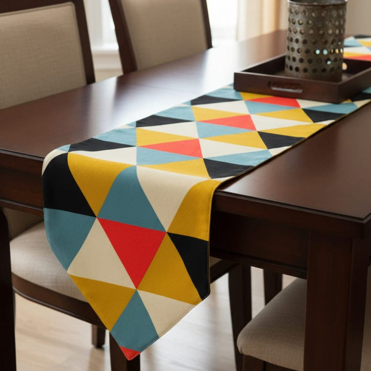 Table runner with colourful triangles on a dark wooden dining table.
