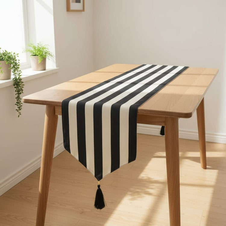 Black and white broad-striped table runner with a tasselled end.