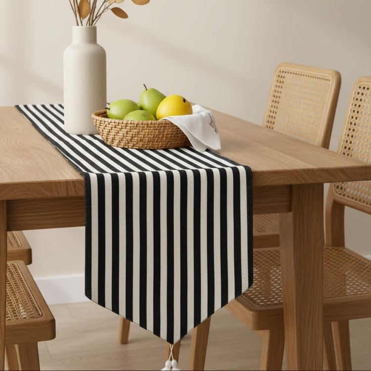 Black and white striped table runner beneath a fruit bowl.