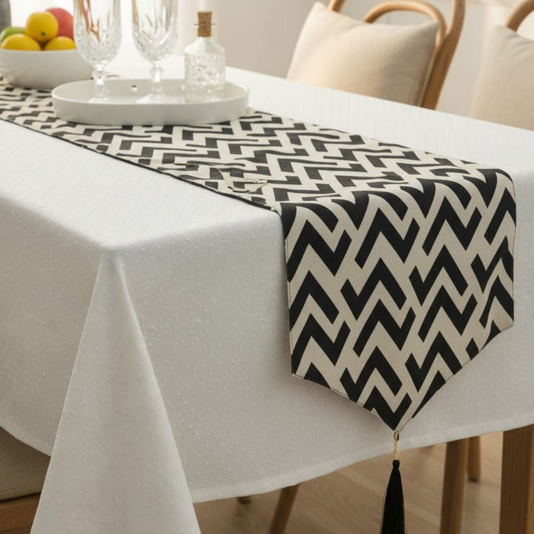 Black and white chevron table runner over a white tablecloth.