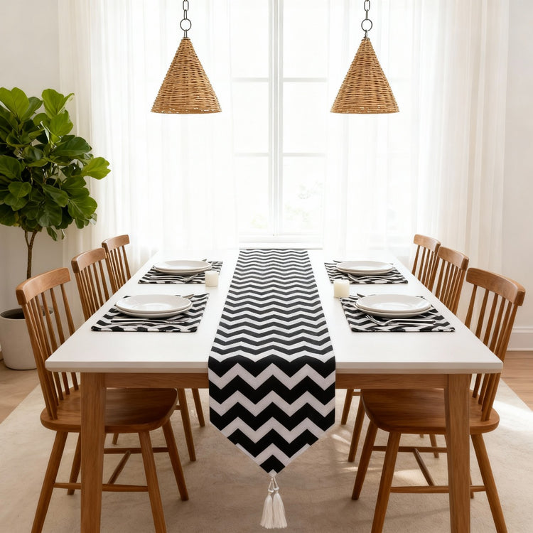 Black and white zigzag table runner with matching placemats on a dining table.