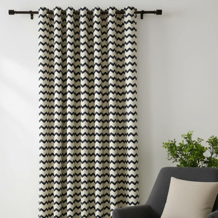Black and white chevron eyelet curtains hanging at a window.