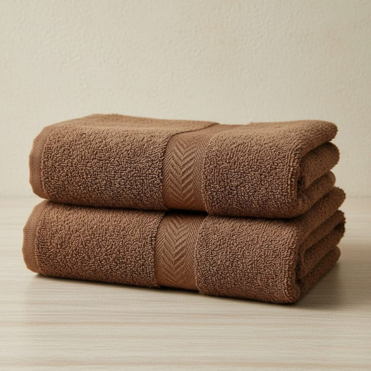 Two folded brown cotton hand towels.