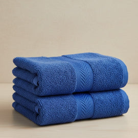 Two folded navy blue cotton hand towels.