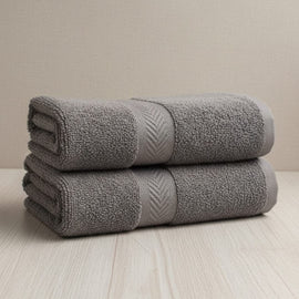 Two folded charcoal grey cotton hand towels.