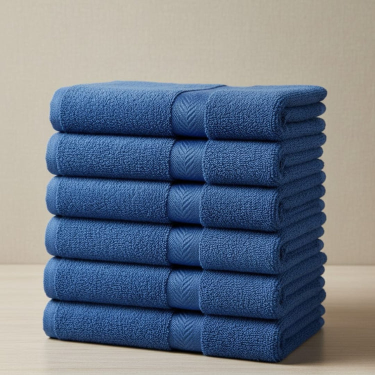 Stack of navy blue cotton hand towels with woven borders.