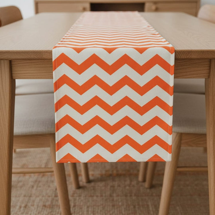 Orange and white chevron table runner on a wooden table.