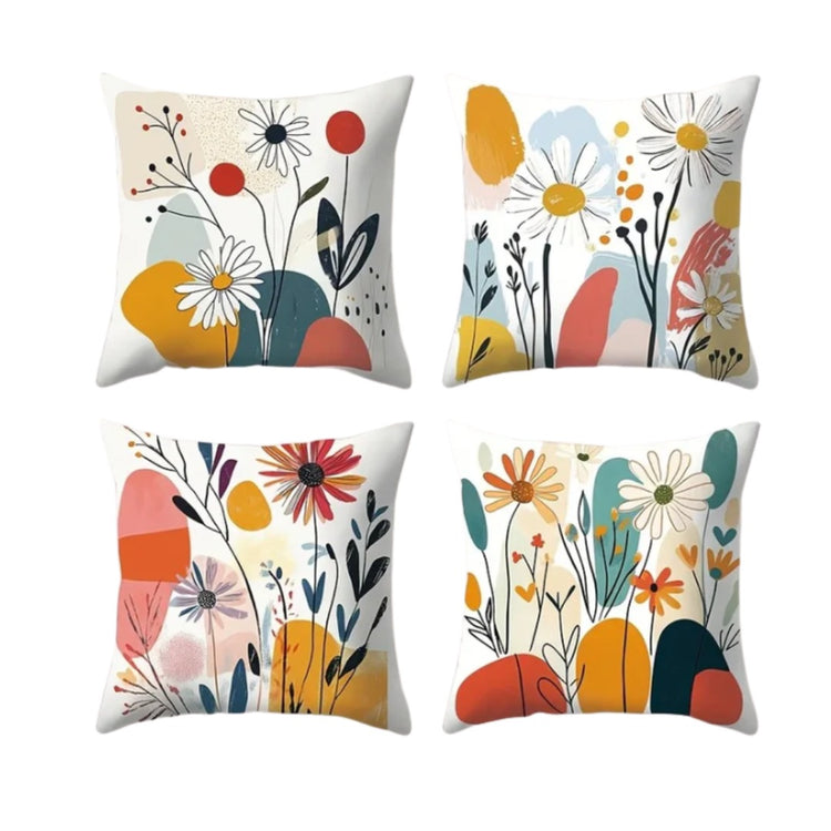Four white cushion covers with daisies, colourful abstract shapes and dark leafy stems.