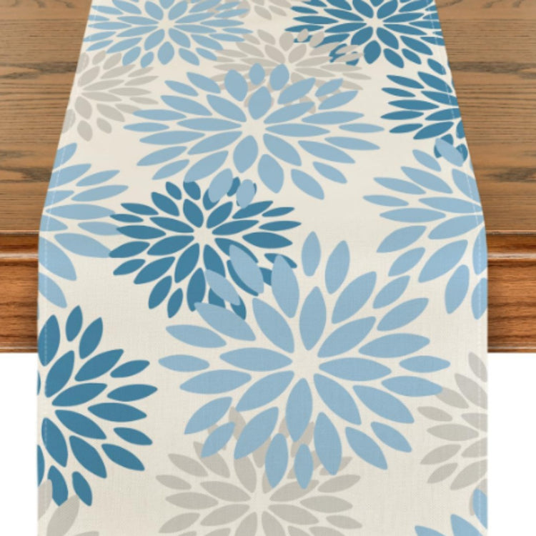 Cream table runner with light and dark blue floral motifs.