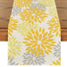 Cream table runner with yellow and grey floral motifs.