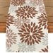 Cream table runner with brown and beige floral motifs.