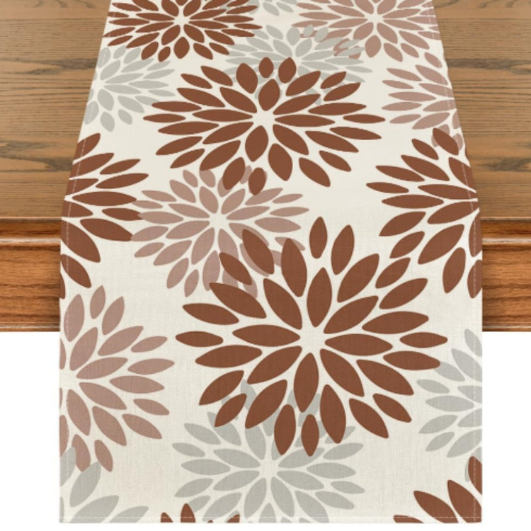 Cream table runner with brown and beige floral motifs.