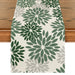 Cream table runner with green floral motifs.
