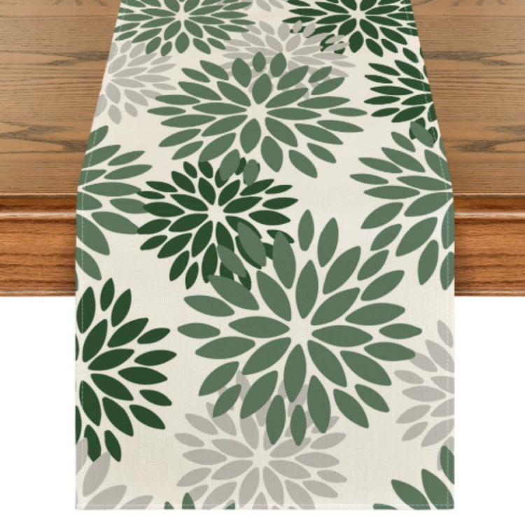 Cream table runner with green floral motifs.