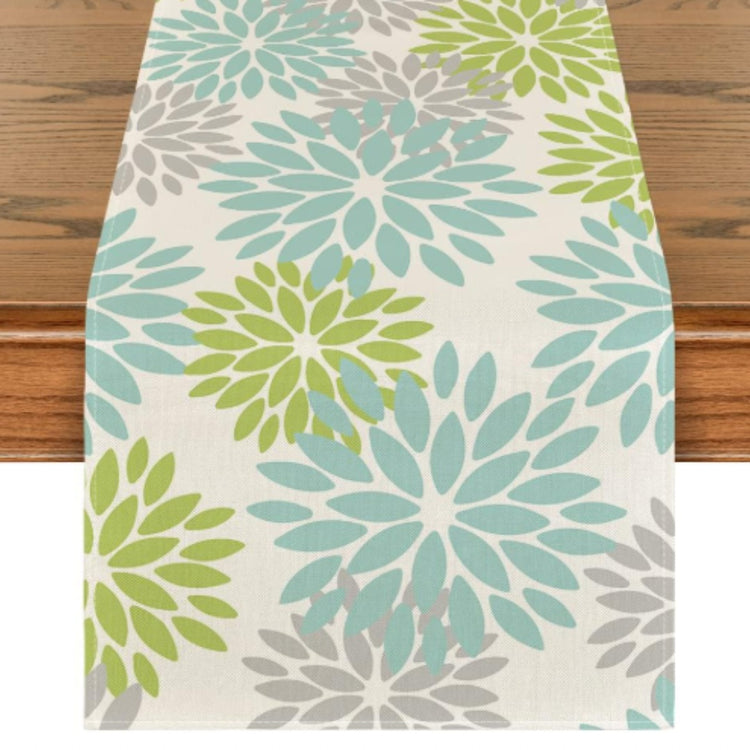 Cream table runner with turquoise and lime green floral motifs.