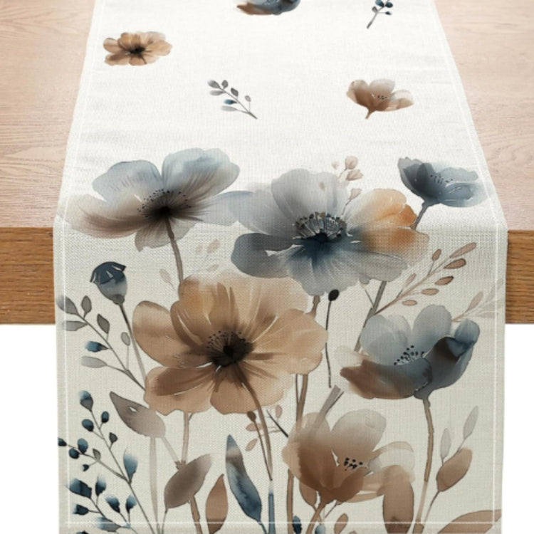 Close-up of blue and beige floral motifs on a cream table runner.