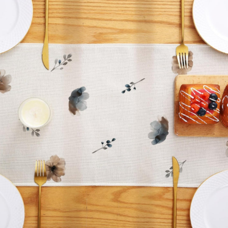 Overhead view of small floral motifs along the centre of a cream table runner.