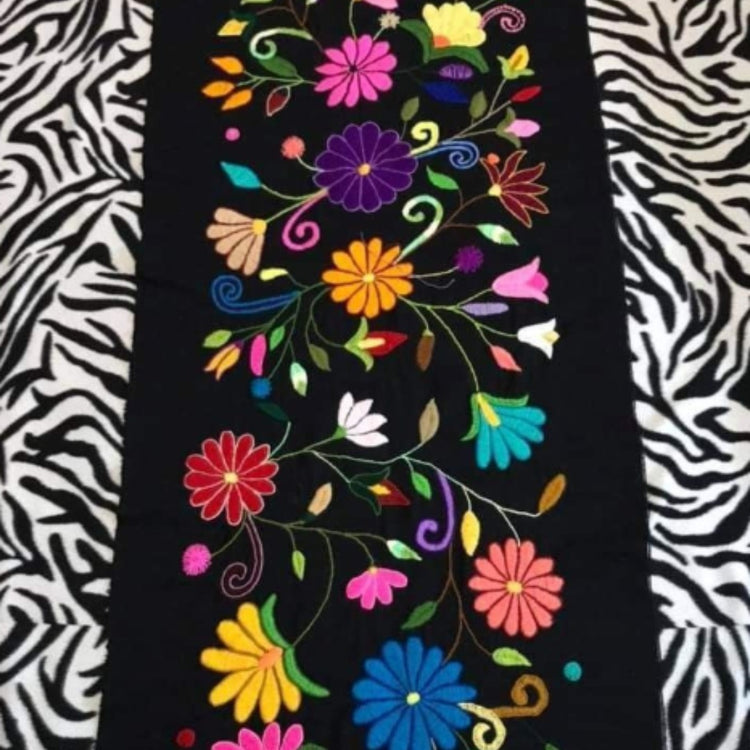 Black table runner with bright floral motifs and black-and-white zebra borders.
