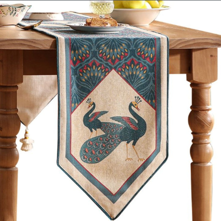 Decorative table runner with peacock illustrations and a teal ornamental border.