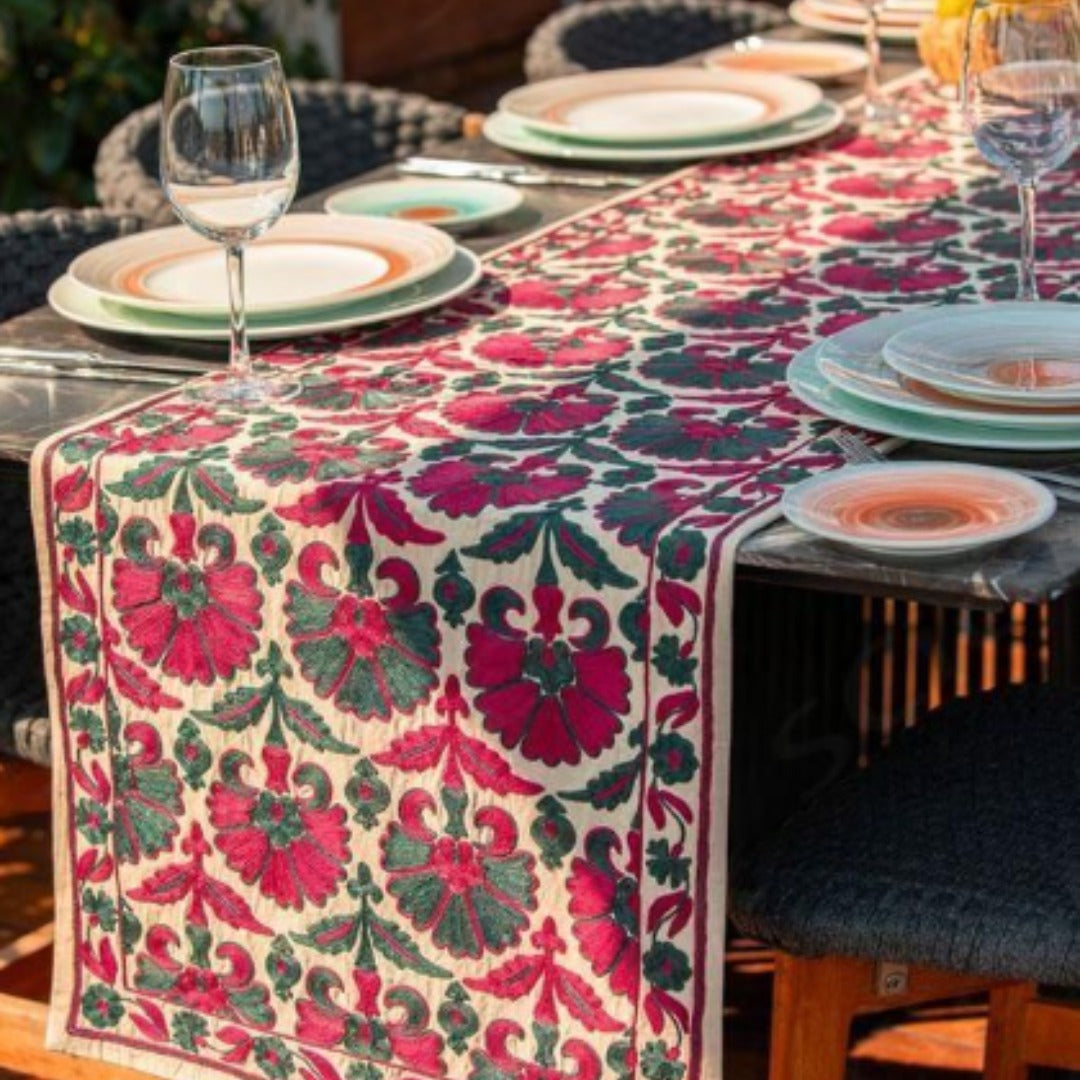 Cream table runner with red and pink floral vines and decorative borders.