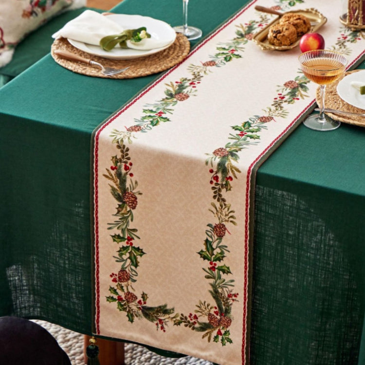Cream table runner with small pink flowers along a green leafy border.
