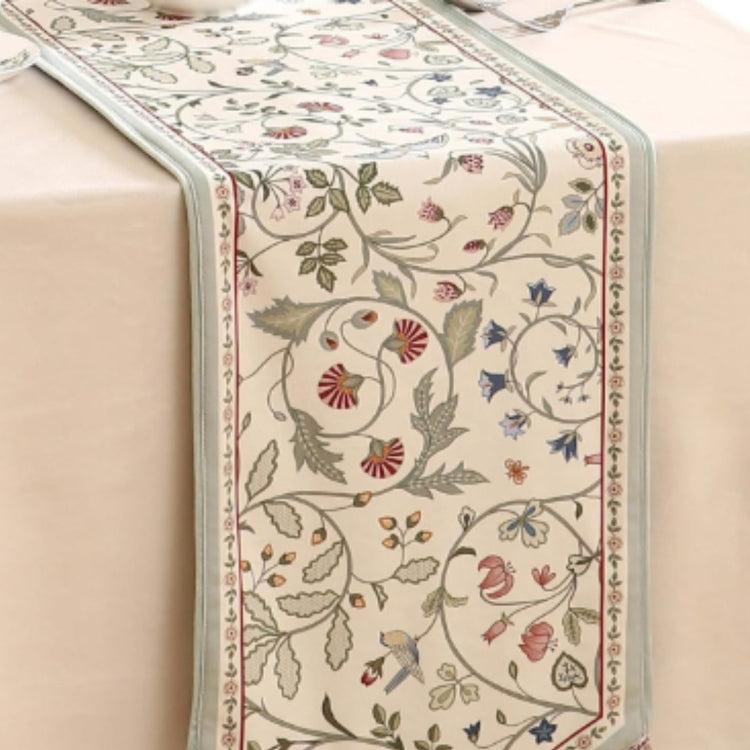 Cream table runner with delicate multicoloured flowers and leafy vines.