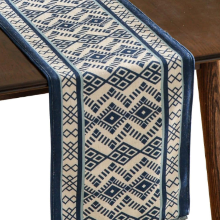 Cream and blue table runner with fine geometric woven-style motifs.