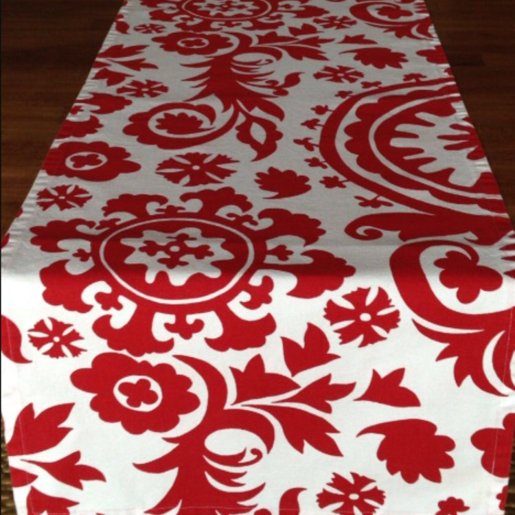 Red and cream table runner with large ornamental damask motifs.
