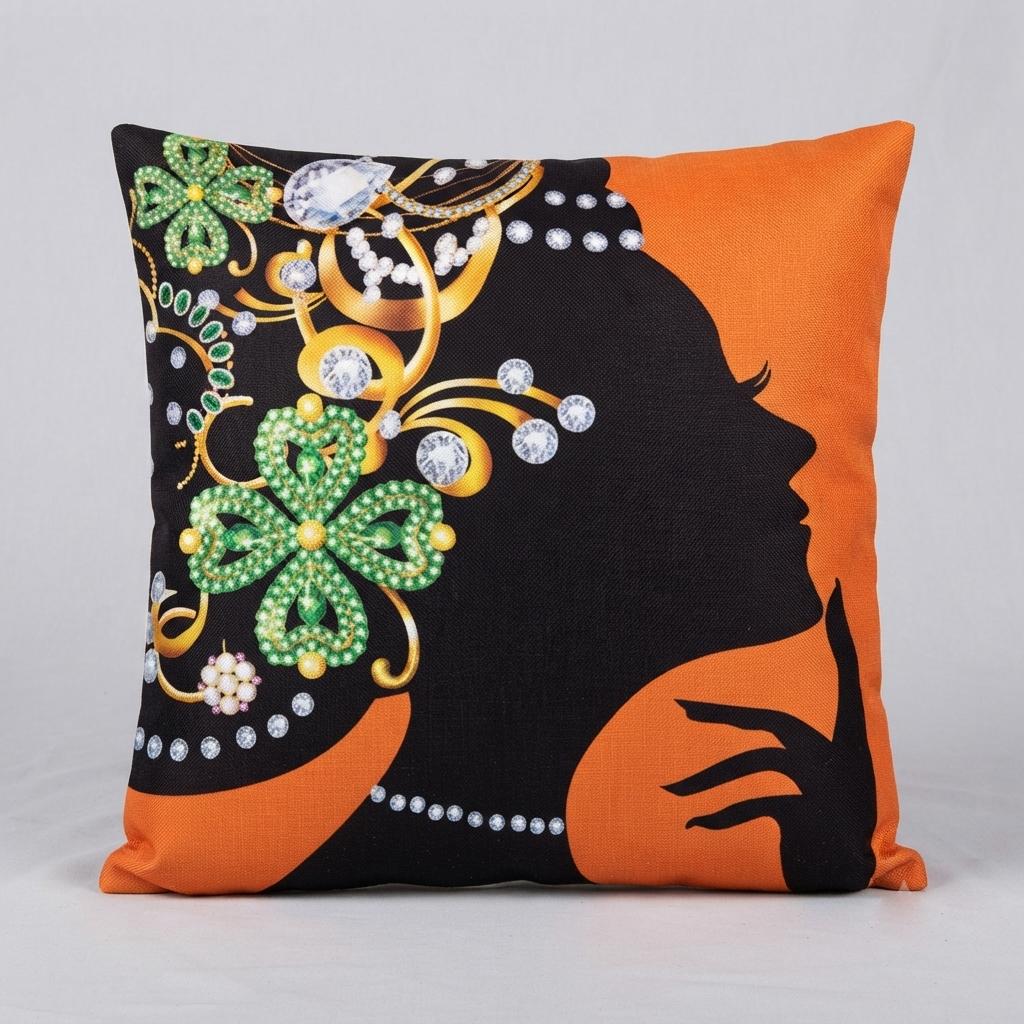 Orange cushion cover with a black profile silhouette and a colourful floral headpiece.