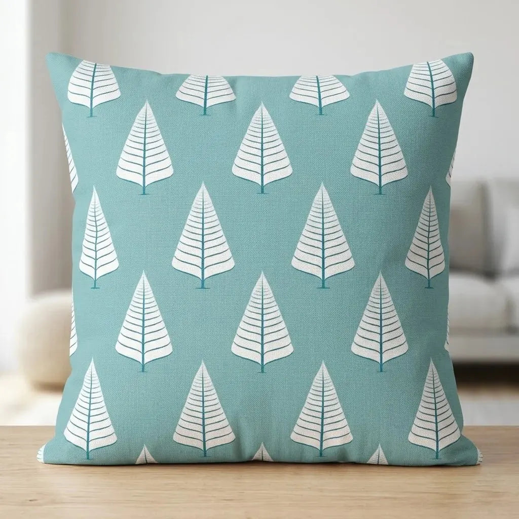 Turquoise cushion cover with rows of white geometric tree shapes.