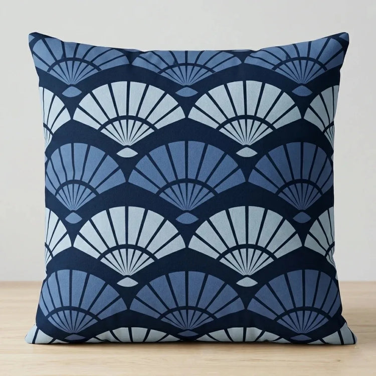 Cushion cover with layered dark and light blue fan-shaped patterns.