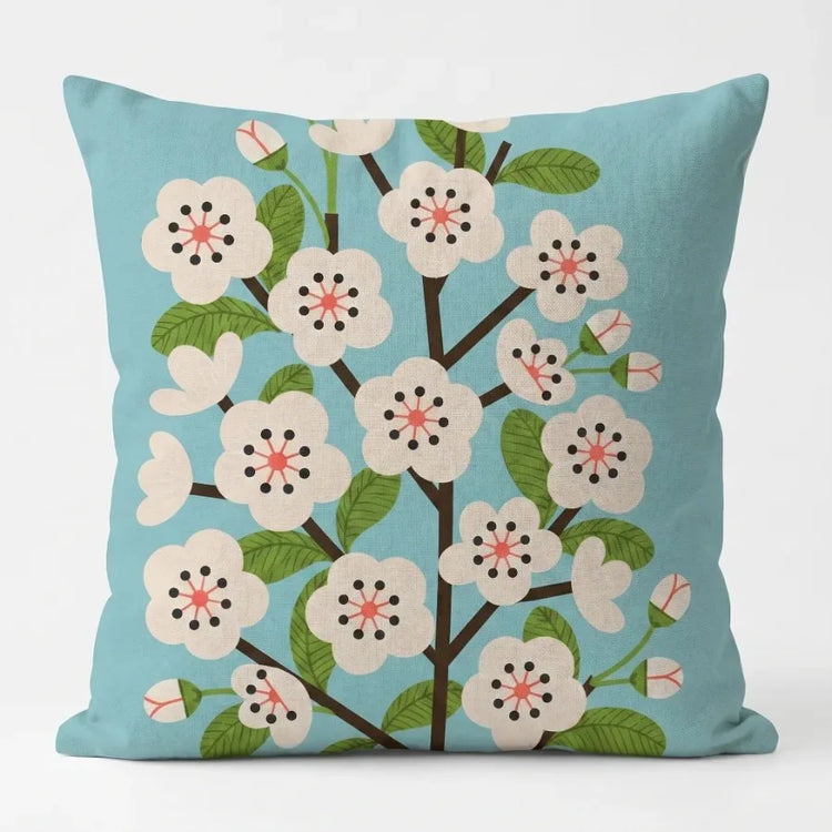 Turquoise cushion cover with a flowering tree and small white blossoms.