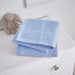Folded pale blue cellular blanket on a white cabinet beside a plush rabbit.