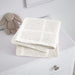 Folded white cellular blanket on a white cabinet beside a plush rabbit.