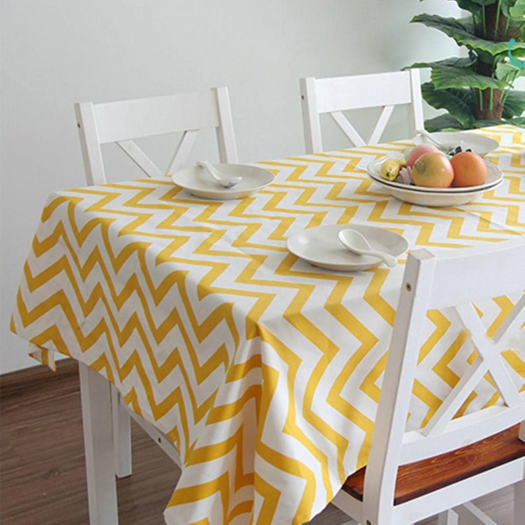Yellow and white chevron tablecloth displayed on a dining table.