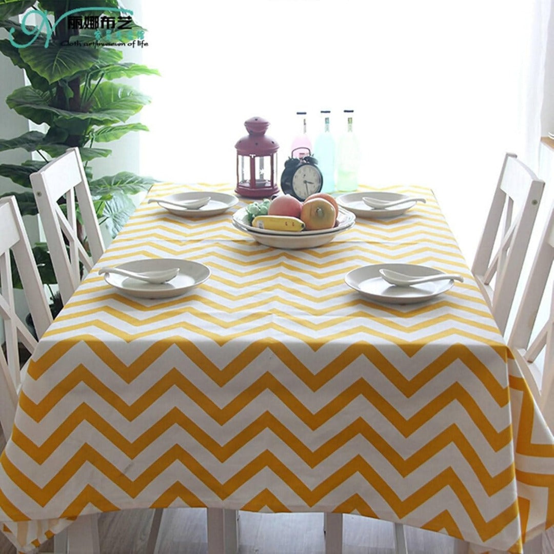 Yellow and white chevron tablecloth displayed on a dining table.