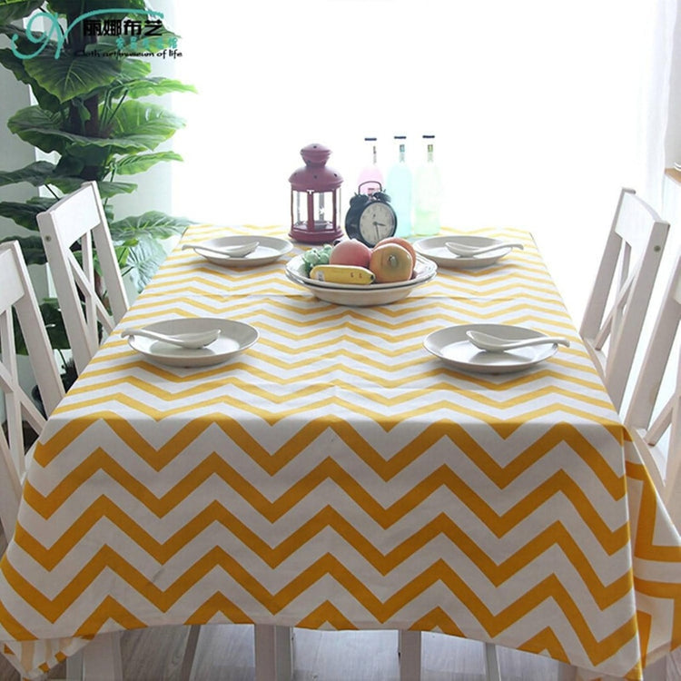 Yellow and white chevron tablecloth displayed on a dining table.